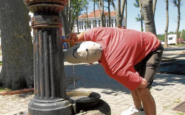 Un joven bebe agua en una fuente de Mundaka. Un joven bebe agua en una fuente de Mundaka.