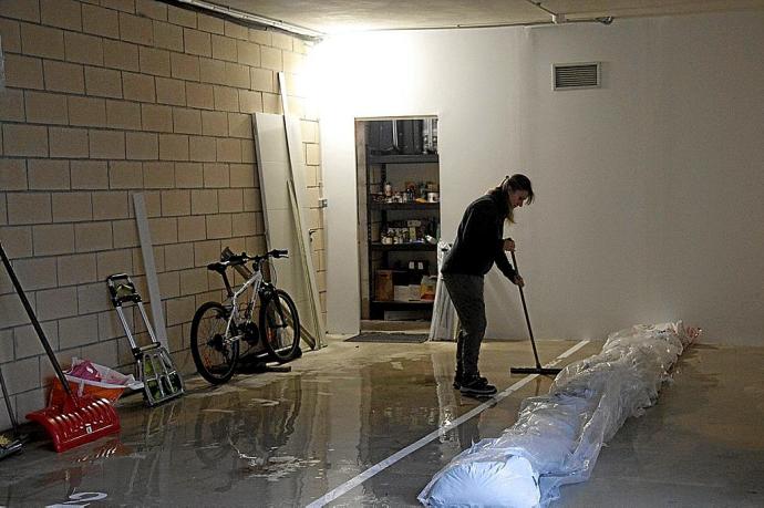 Una joven limpia en Durana la cochera que se había inundado. Foto: Josu Chavarri