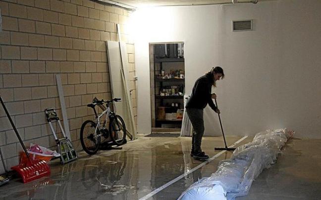 Una joven limpia en Durana la cochera que se había inundado. Foto: Josu Chavarri