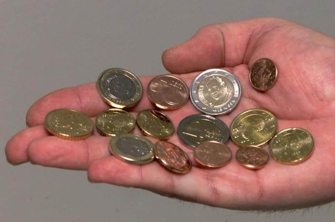 Una mano sostiene varias monedas que se gastarán rápidamente.