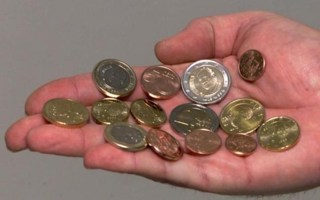 Una mano sostiene varias monedas que se gastarán rápidamente. Una mano sostiene varias monedas que se gastarán rápidamente.