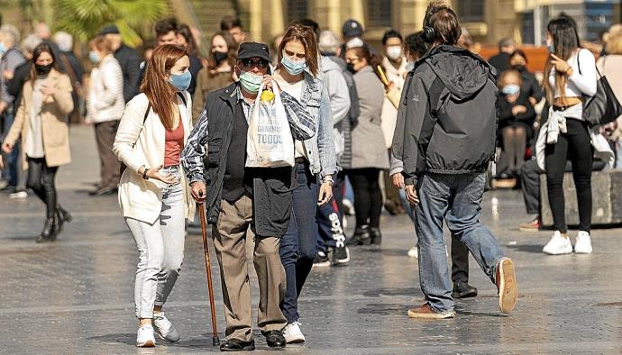 Varias personas, protegidas con mascarilla, pasean por una zona céntrica de Donostia. Foto: Ruben Plaza