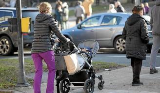 Una mujer ajena a esta información empuja un carrito de bebé por una calle de la capital alavesa.