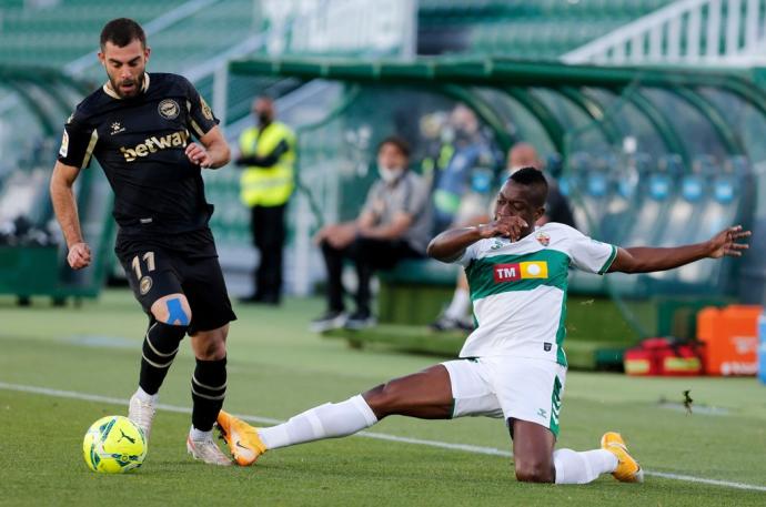 El delantero del Alavés Luis Rioja juega un balón ante Omenuke Mfulu, del Elche