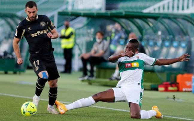 El delantero del Alavés Luis Rioja juega un balón ante Omenuke Mfulu, del Elche