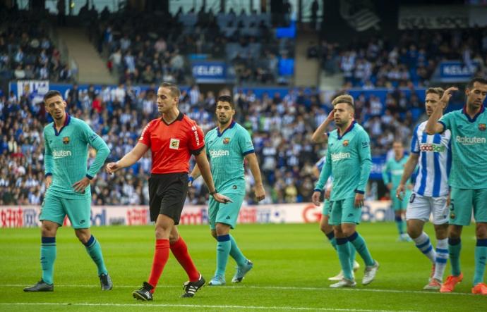 Alberola Rojas, protestado por los jugadores del Barça tras señalar penalti a favor de la Real, en diciembre de 2019.