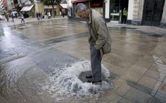 Un hombre sobre una alcantarilla de Vitoria tras un reventón, en una imagen de archivo