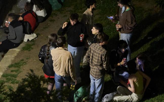 Jóvenes consumen alcohol en un parque.