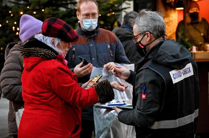 Un inspector verifica los certificados de vacunación en un mercado navideño de Colonia.
