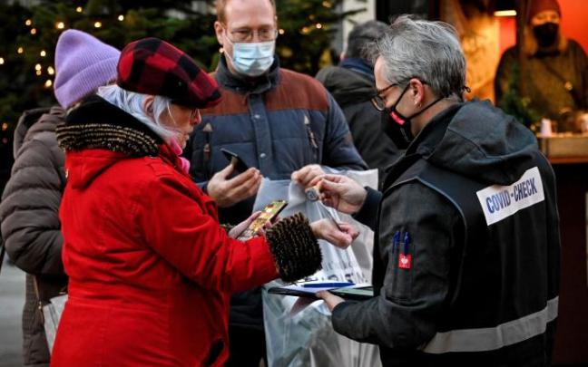 Un inspector verifica los certificados de vacunación en un mercado navideño de Colonia.
