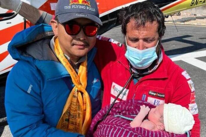 Alex Txikon, con el bebé tras descender del helicóptero en Katmandú.