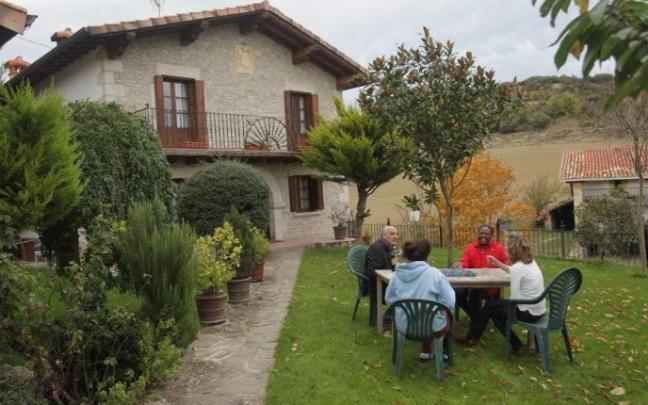 Un grupo de turistas disfrutan en el jardín de una casa rural Un grupo de turistas disfrutan en el jardín de una casa rural
