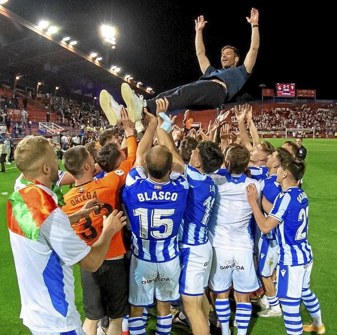 Los futbolistas del Sanse mantean a Xabi Alonso tras la consecución del ascenso en Almendralejo. Foto: Real Sociedad
