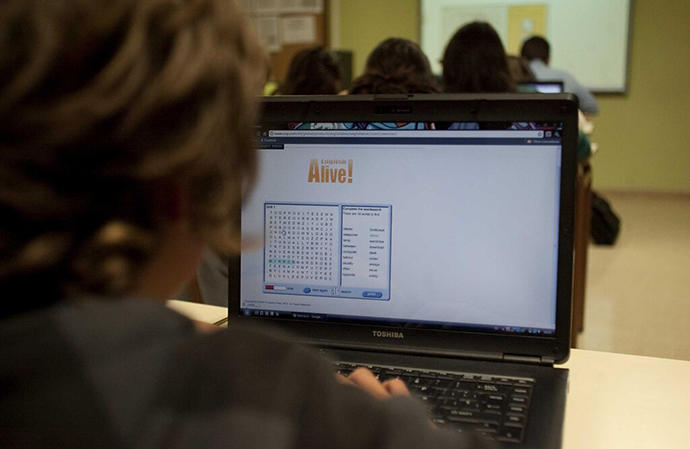 Un alumno con su ordenador portátil durante una clase de informática impartida en inglés.