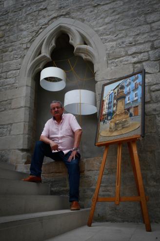 Álvaro Mundiñano posa con su cuadro de la fuente de Nabarreria, uno de los puntos de encuentro de la parte vieja de Pamplona.