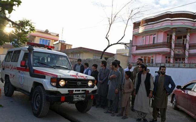 Varios viandantes se paran junto a una ambulancia cerca del lugar de una explosión en Kabul. Varios viandantes se paran junto a una ambulancia cerca del lugar de una explosión en Kabul.