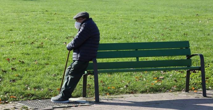 Anciano apoyado en un banco