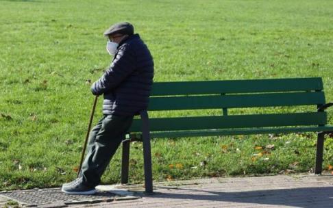 Anciano apoyado en un banco