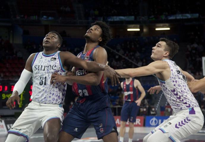 Ángel Delgado y Álex Reyes pugnan por un rebote con Enoch.