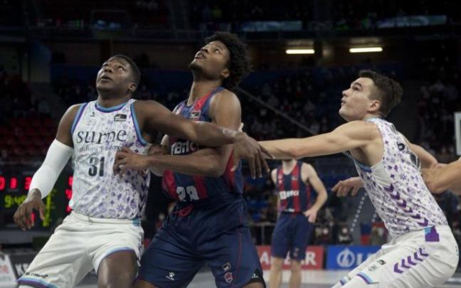 Ángel Delgado y Álex Reyes pugnan por un rebote con Enoch.