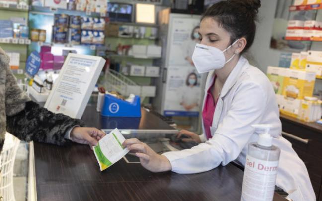 Una farmacéutica muestra un test de antígenos. Una farmacéutica muestra un test de antígenos.