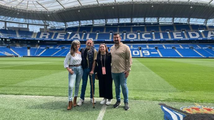 Antonio Escandón y su familia, sobre el césped del nuevo Anoeta. Al fondo, la cubierta desde la que se cayó en julio de 2019