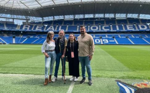 Antonio Escandón y su familia, sobre el césped del nuevo Anoeta. Al fondo, la cubierta desde la que se cayó en julio de 2019