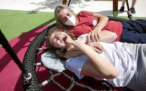Una niña disfruta entre risas de uno de los columpios del parque junto con su cuidadora. Una niña disfruta entre risas de uno de los columpios del parque junto con su cuidadora.