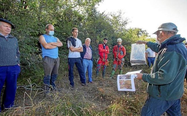 1. Paco Etxeberria, mostrando las abarcas halladas en la anterior visita.2. Un espeleólogo de Sakon entra a la sima.3. Restos óseos en el interior de la sima Foto: cedida