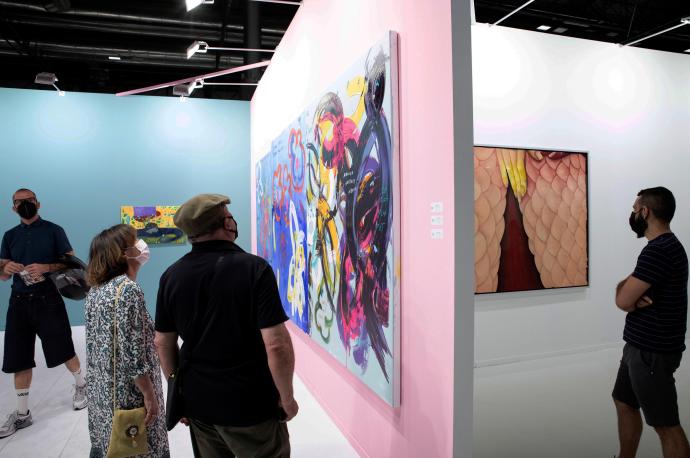 Varias personas observan diferentes obras en su visita a la Feria ARCO.