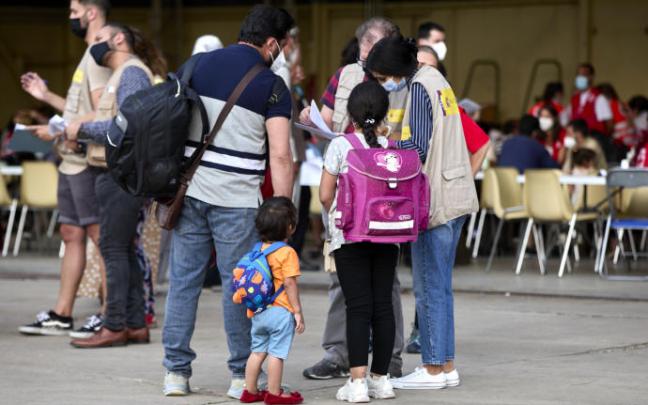 Varios refugiados afganos recibiendo indicaciones en Torrejón de Ardoz (Madrid).