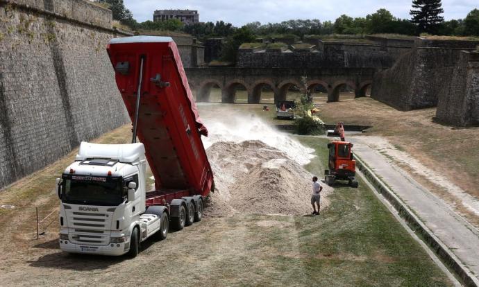 Uno de los camiones descarga las toneladas de arena en los fosos de la Ciudadela.