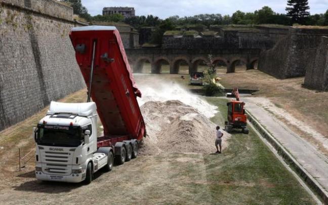 Uno de los camiones descarga las toneladas de arena en los fosos de la Ciudadela. Uno de los camiones descarga las toneladas de arena en los fosos de la Ciudadela.