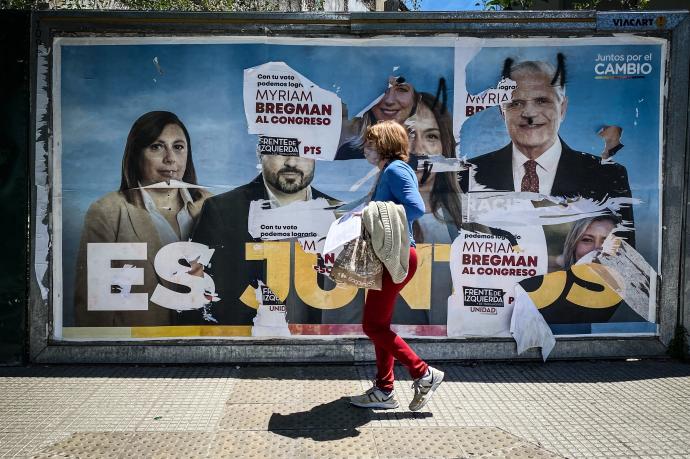 Una mujer ante un cartel con publicidad electoral en Buenos Aires