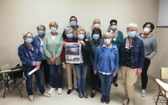 Un grupo de voluntarias y voluntarios de Cáritas Arratia muestra el cartel de festival.