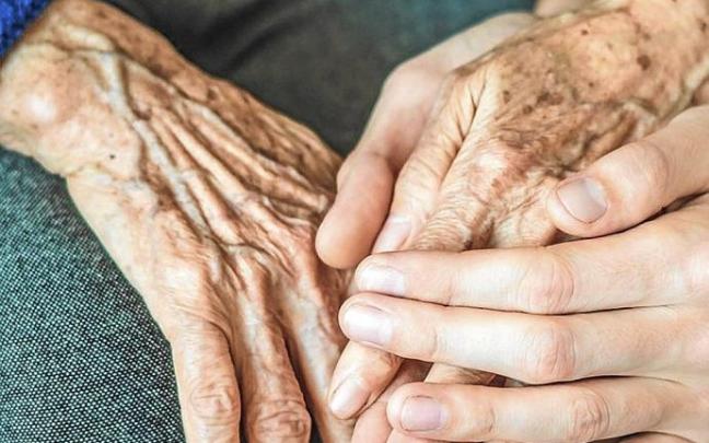 Adineko pertsona baten eta gazte baten esku batzuen irudia. Utzita