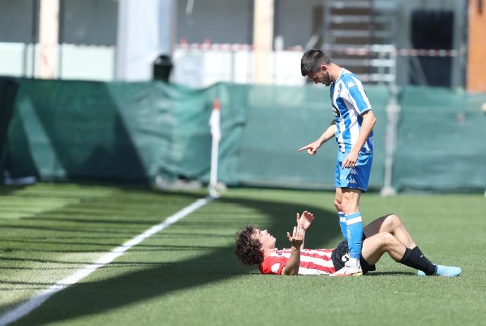 Artola, tendido sobre el césped, es recriminado por un jugador del Depor.