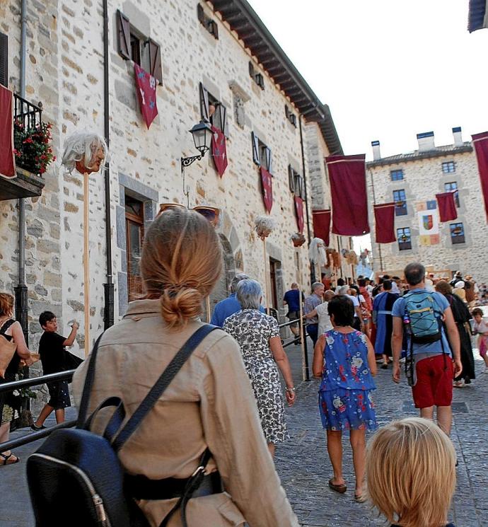 Visitantes recorren el casco histórico de la localidad alavesa de Artziniega durante una jornada festiva.