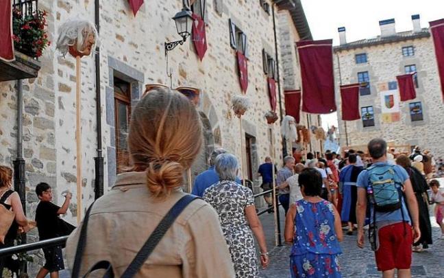 Visitantes recorren el casco histórico de la localidad alavesa de Artziniega durante una jornada festiva.