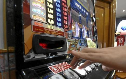 Una persona utilizando una máquina tragaperras.