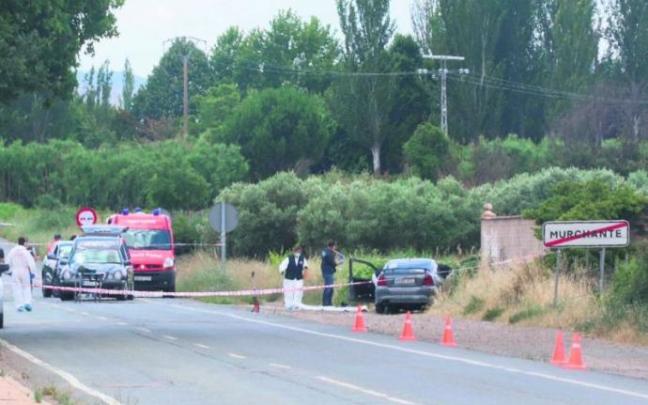 Agentes de la Policía Foral junto al turismo de la mujer asesinada, justo a la salida del municipio.