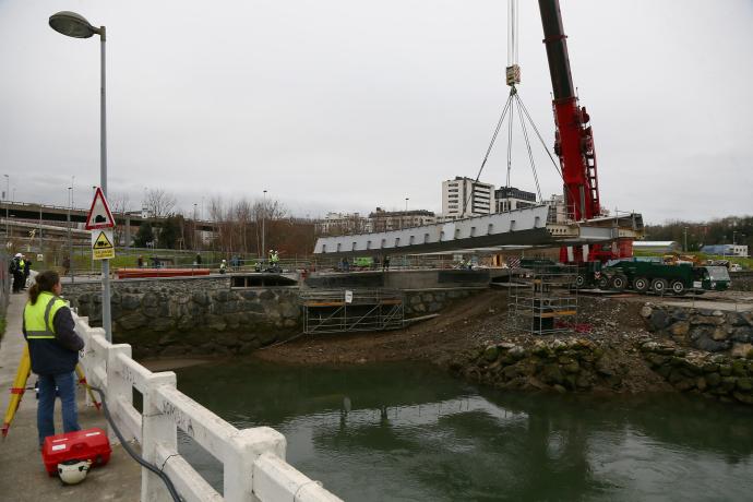 La grúa traslada uno de los vanos que compondrá el puente, con el 'cabezón' ya colocado.