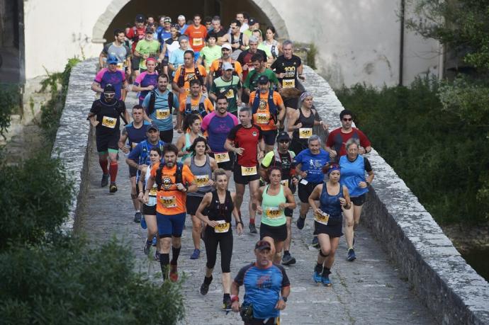 Decenas de corredores en atravesando un puente durante la Atarrabi Trail