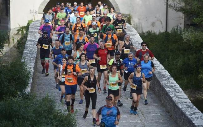 Decenas de corredores en atravesando un puente durante la Atarrabi Trail