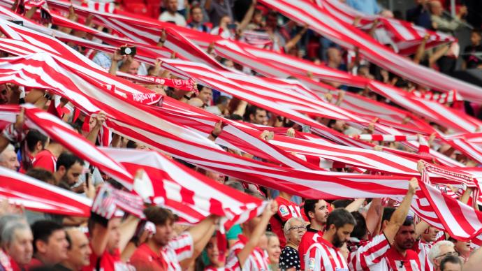 Aficionados del Athletic alzan sus bufandas en un partido en San Mamés.