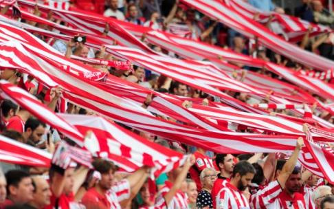 Aficionados del Athletic alzan sus bufandas en un partido en San Mamés.