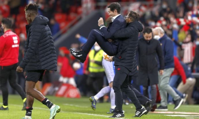 Marcelino García Toral es levantado por su preparador físico, Ismael Fernández, tras lograr el pase a cuartos.'