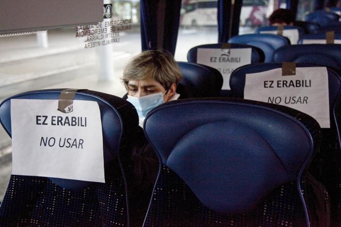 Asientos inhabilitados en un autobús durante el primer estado de alarma, con una persona ajena a la información