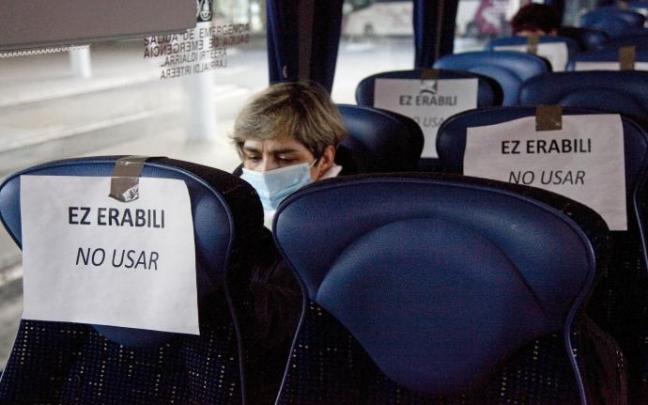 Asientos inhabilitados en un autobús durante el primer estado de alarma, con una persona ajena a la información