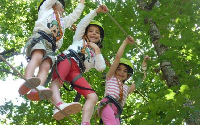 Tres txikis hacen arborismo en Bertiz Aventura.